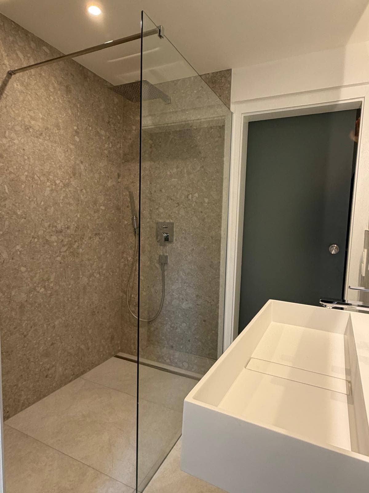 Modernisiertes Badezimmer mit bodengleicher Walk-in-Dusche und großformatigen Fliesen, weitere Projektansicht 3